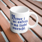 Preview: Gemütliche Kaffeepause mit der weißen Keramiktasse „Bevor i mi aufreg, is ma liaba wurscht“ in der Hand.