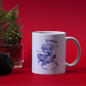 Preview: Weiße Keramiktasse mit Löwe-Sternzeichen Motiv, ideal für die festliche Weihnachtszeit.