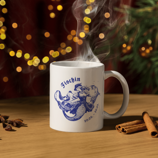 Weiße Keramiktasse mit Fische Sternzeichen Motiv (weiblich), dekoriert auf einem festlich gedeckten Weihnachtstisch